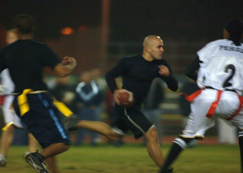 INCIRLIK AIR BASE, Turkey --  Airman First Class Nolan Palazolla, 39th Security Forces Squadron quarterback, runs the ball for 10 yards for the against the 39th Logistics Readiness Squadron during Inramual flag football playoff action Nov. 7.  SFS came out on top 20-19 after a close game with LRS.  (U. S. Air Force photo by Airman First Class Nathan W. Lipscomb)