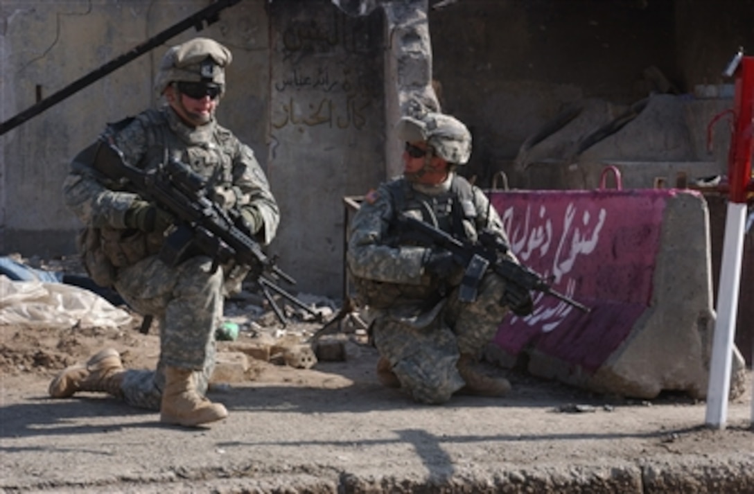 U.S. Army Spc. Henry Pondolfino (left) and Cpl. Christopher Jensen provide security during a presence patrol in Hasawah, Iraq, on Nov. 4, 2006.  Pondolfino, Jensen and their fellow soldiers from Delta Company, 3rd Battalion, 509th Parachute Infantry Regiment, are patrolling through Hasawah.  