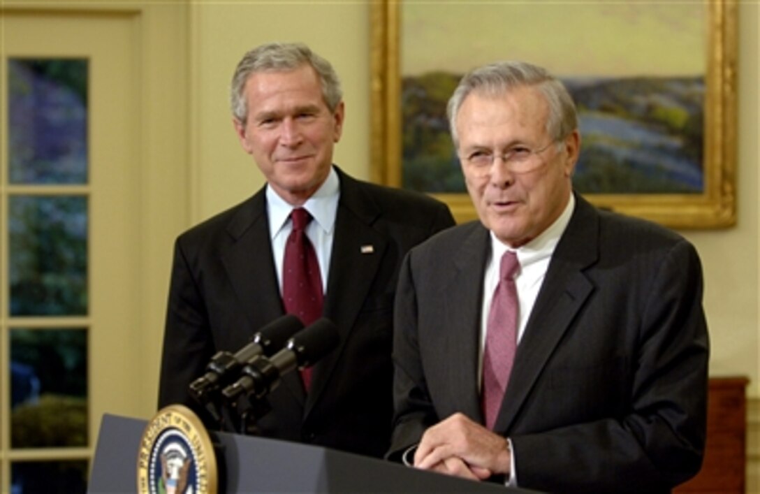 President George W. Bush looks on as Defense Secretary Donald H. Rumsfeld addresses the nation during a news conference, Nov. 8, 2006, from the East Room of the White House. 