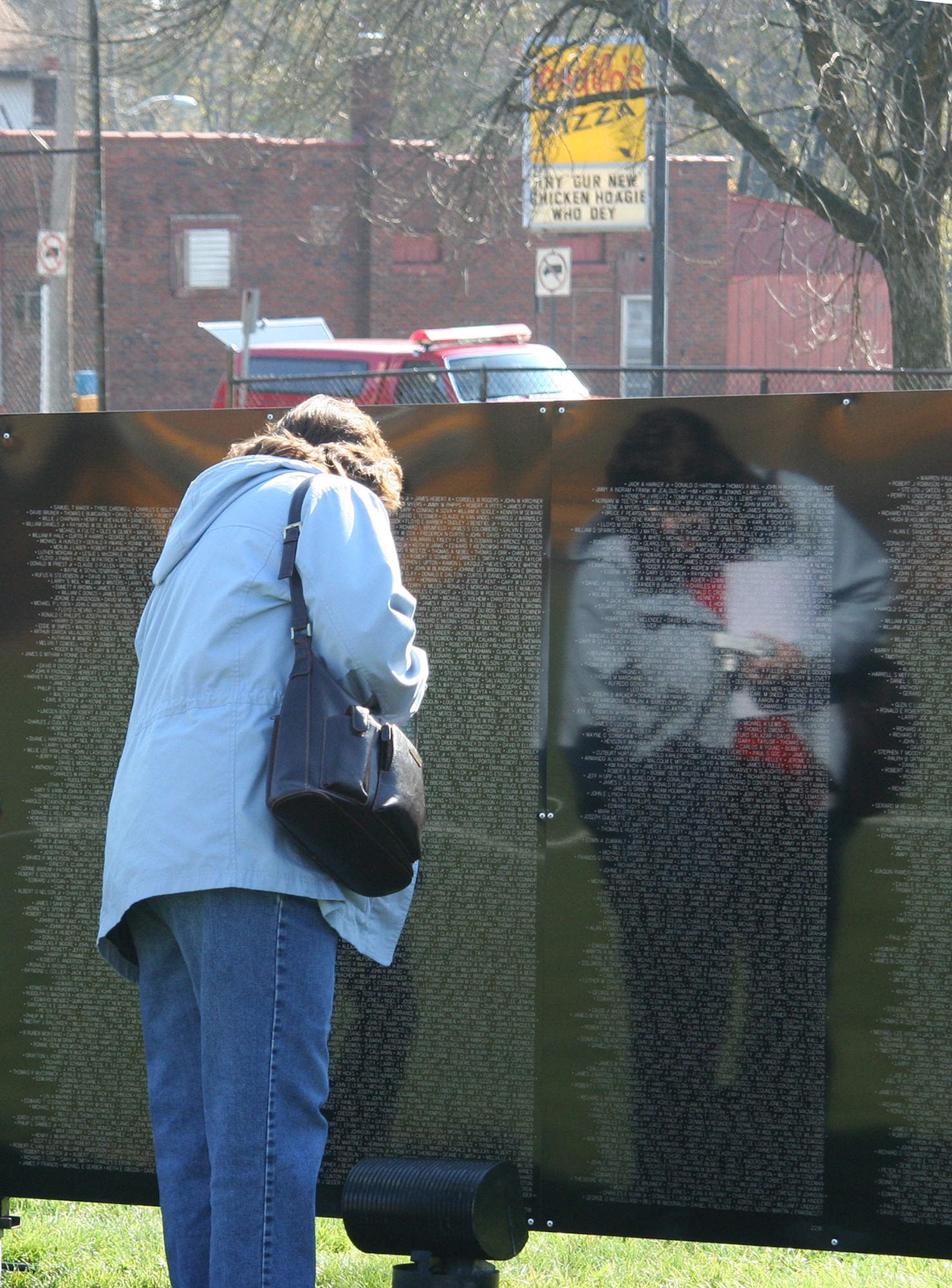 Cincinnati, Ohio – An unidentified woman looks at the names on “The Wall That Heals” at Dorl Field in Norwood, Ohio, a suburb of Cincinnati. The traveling Vietnam Wall will be there over Veteran's Day weekend.  The travel wall started in 1984 travels to 22 to 28 cities a year and is visited by several thousand people at each spot.  (U.S. Air Force Photo/Maj. Ted Theopolos).