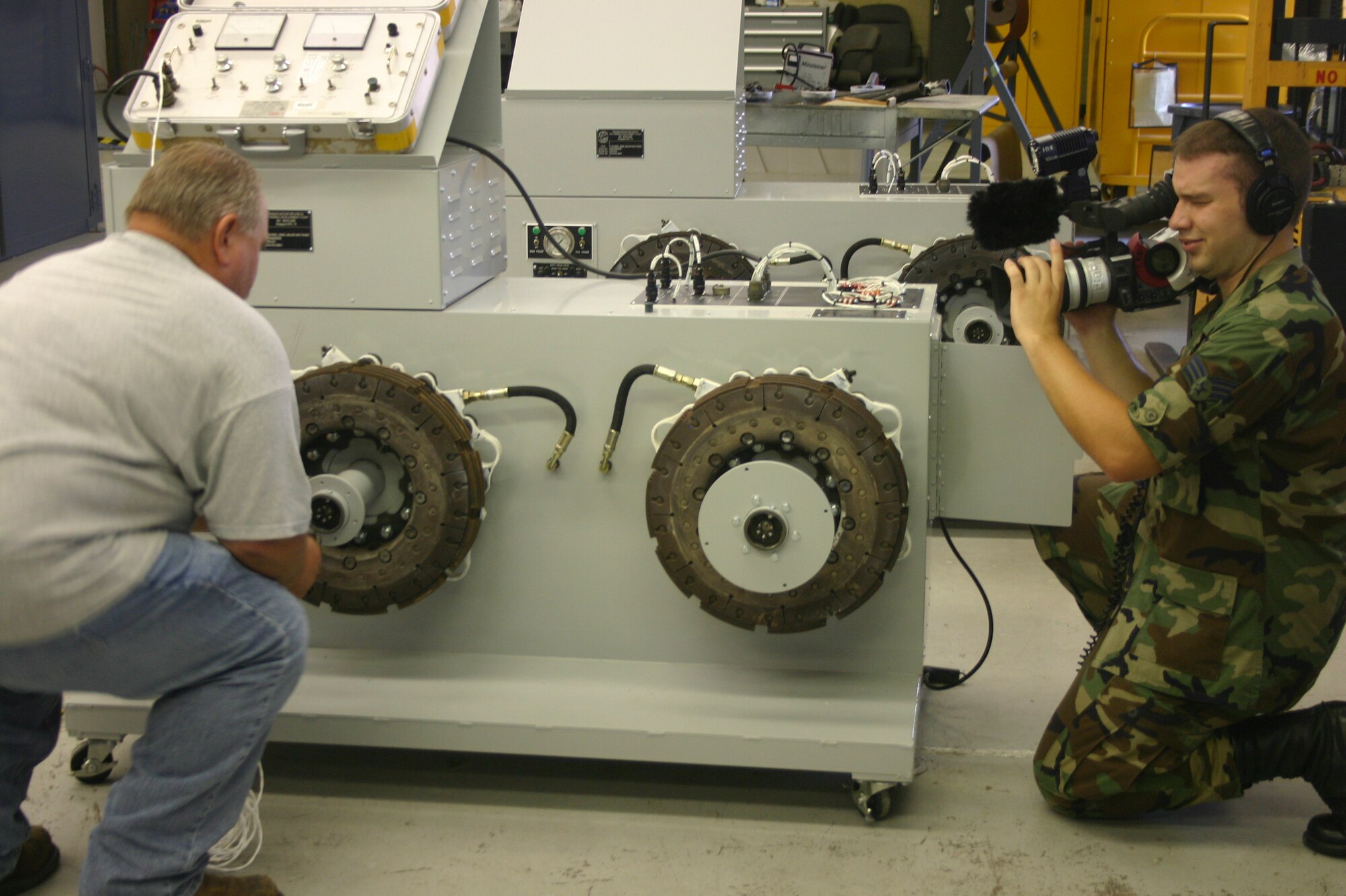 Senior Airman Brad Cameron, a broadcast journalist with Air Force News, films the 982nd Training Group’s Don Kraft as he demonstrates how the C-130 anti-skid trainer works. The feature is scheduled to run on AFNEWS today. (U.S. Air Force photo/Robert Fox).