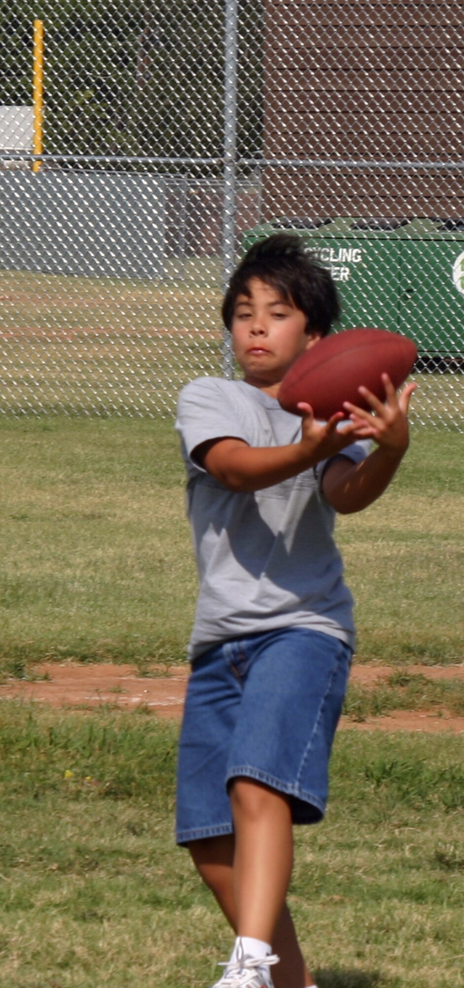 Ryan Stevens catches the ball during a flag football game at the youth centers summer sports camp. (U.S. Air Force photo/Amn Jacob Corbin).