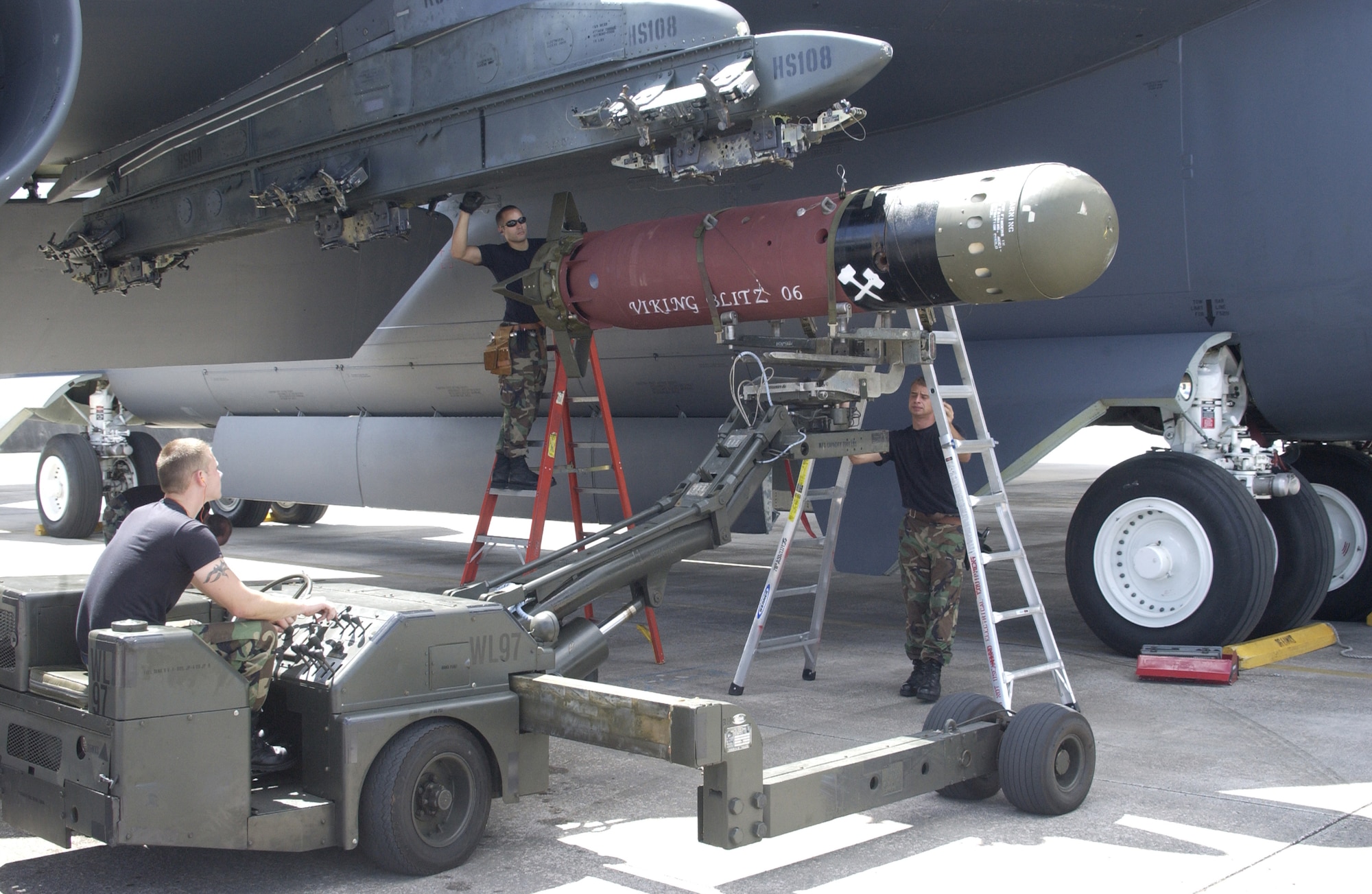 ANDERSEN AIR FORCE BASE, Guam – Staff Sgt. Joshua Sweet (right) gives directions to Airman 1st Class Wayne Robinson (left) while positioning a Mk 56 mine under the wing of a B-52 Stratofortress.  Once in position, SSgt Jason Smith (middle) and Sergeant Sweet will secure the weapon to the heavy stores adapter beam.  These 36th Expeditionary Aircraft Maintenance Squadron weapons loaders were critical in the success of a joint week-long mine exercise which concluded Nov 3.  (U.S. Air Force photo by Staff Sgt. Eric Petosky)