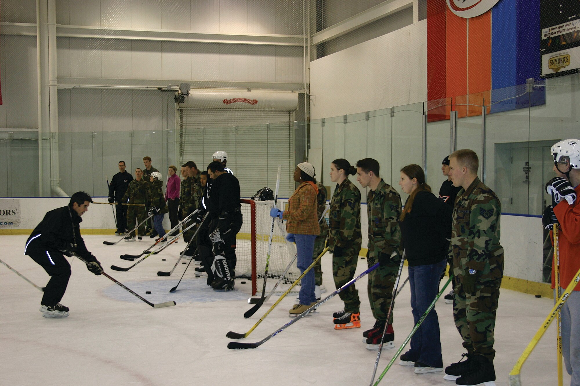 An instructor for the Philadelphia Flyers on-ice clinic trains Team McGuire Airmen and family members on proper ice hockey maneuvering techniques during a Flyers practice session Wednesday in Voorhees, N.J. McGuire members were also invited to attend a Flyers game Saturday in honor of Veterans’ Day.