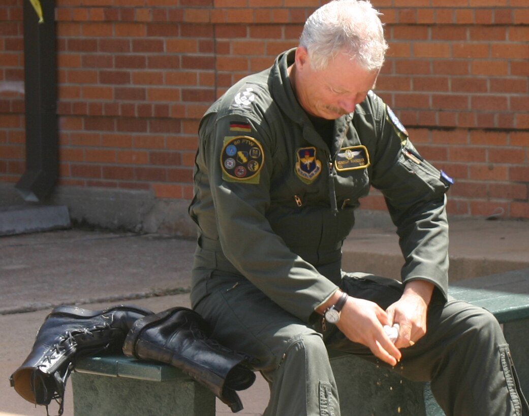 Col. Heinrich Schneider wrings water out of his socks June 23 after he was hosed down following his final flight as the 80th Operations Group commander. (U.S. Air Force photo/Senior Airman Tonnette Thompson).