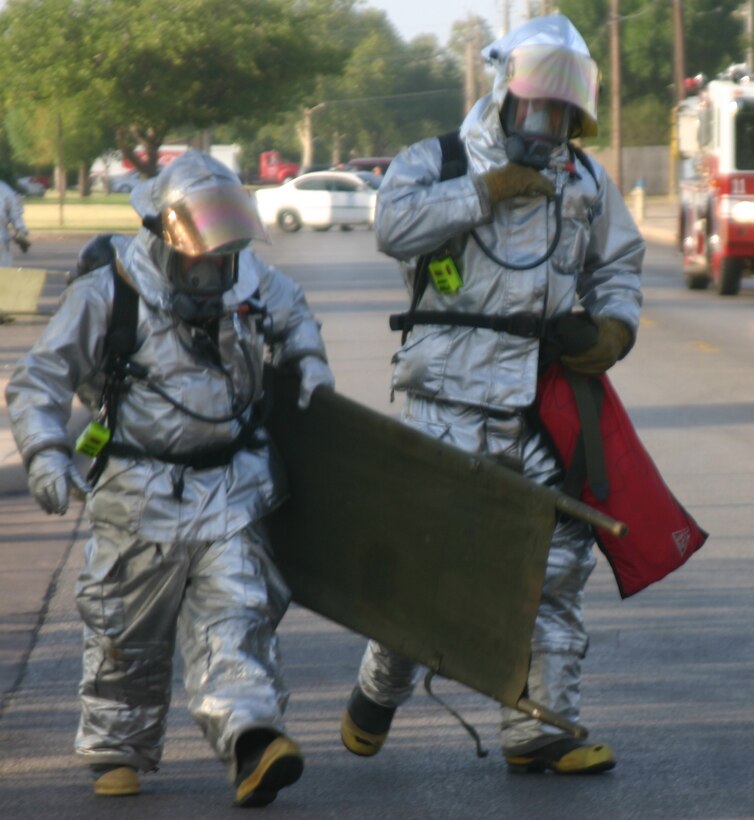 Members of the Sheppard Fire Department carry equipment to help the injured near the community center during Wednesday's exercise. (U.S. Air Force photo/John Ingle)