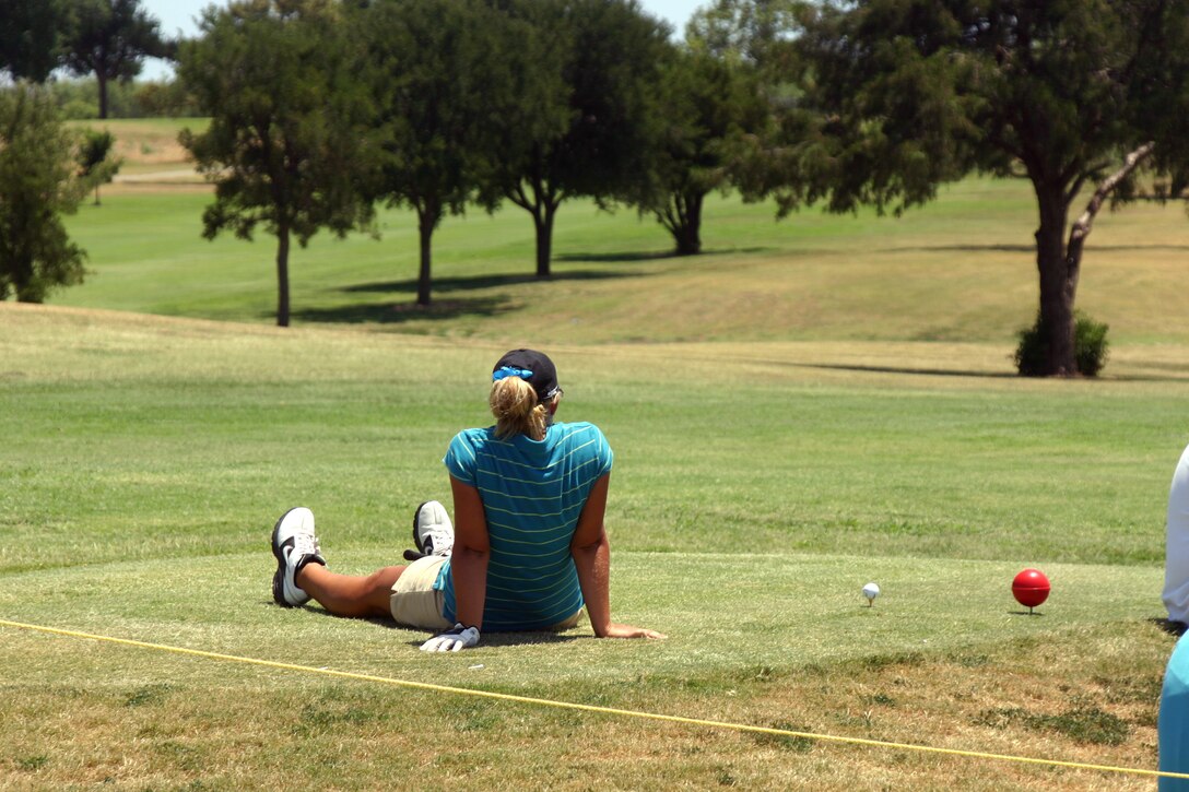 participant in the Texas-Oklahoma Junior Golf Tournament Monday rests while waiting to tee off.  (U.S. Air Force photo/Airman Jacob Corbin).