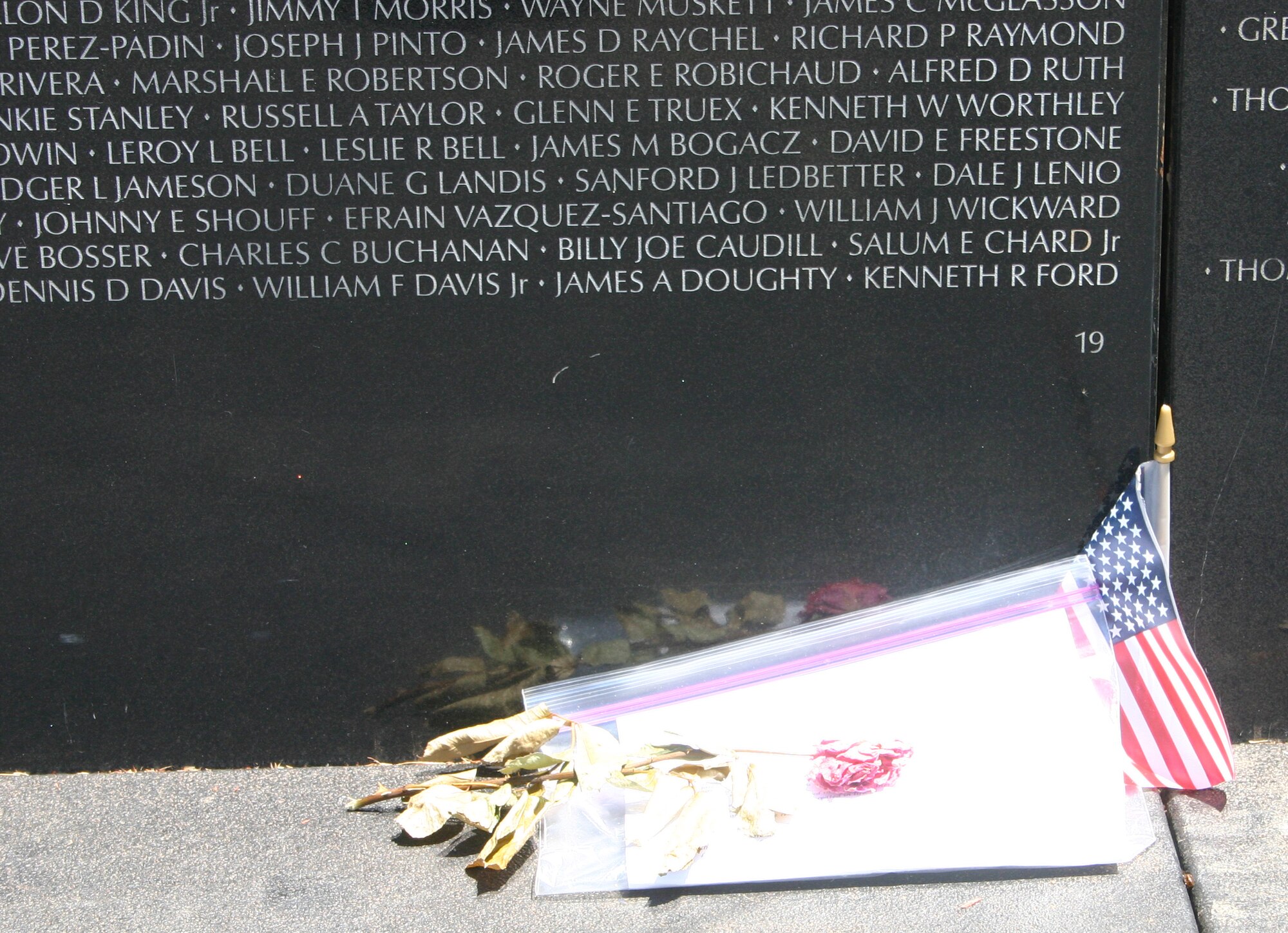 A single rose lays at the base of section 19 of the Vietnam Moving Wall as a tribute to fallen military personnel. The Moving Wall traveled to Wichita Falls June 13 and was open to the public June 16 through Sunday. (U.S. Air Force photo/Senior Airman Tonnette Thompson).