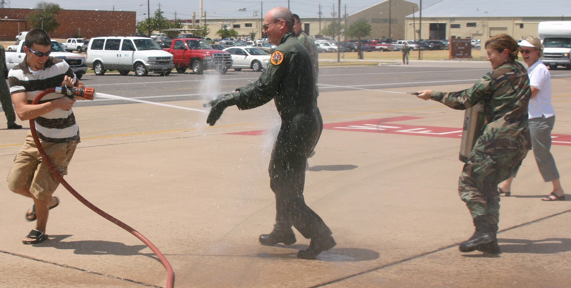 James Whitmore, left, tries to stay dry Aug. 18 as he "congratulates" his father, 82nd Training Wing Commander Brig. Gen. James Whitmore, following his final flight at Sheppard. General Whitmore's executive officer, Capt. Jeanine Hatfield, gets in on the action, too. (U.S. Air Force photo/John Ingle)