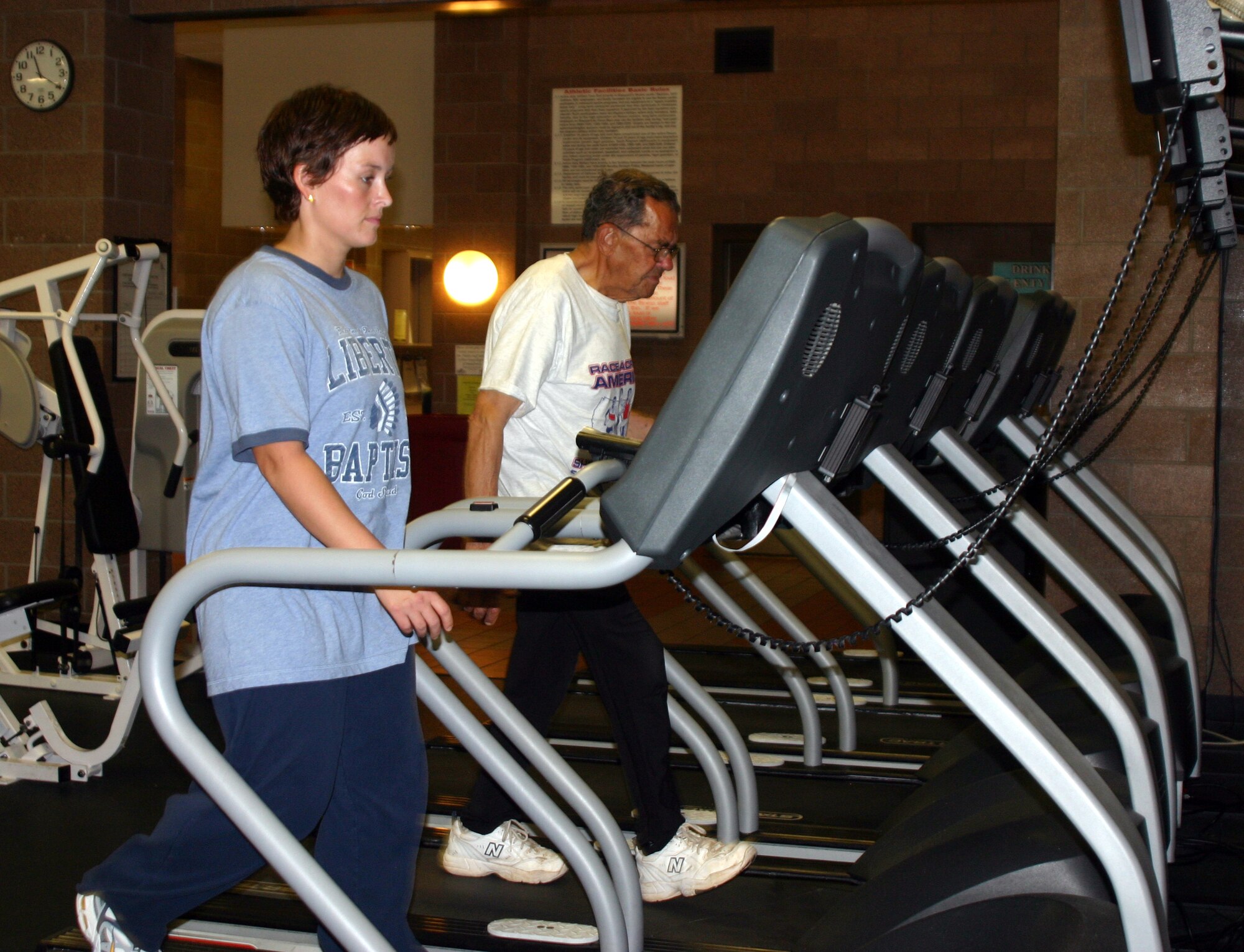 Amy Preskitt and Donnie Dow walk on treadmills at the Levitow Fitness Center Tuesday. Preskitt and Dow are the first participants in the Race Across America fitness event to reach the 500-mile mark. (U.S. Air Force photo/Airman Jacob Corbin)