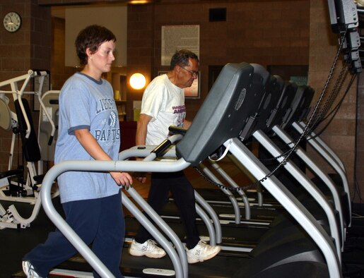 Amy Preskitt and Donnie Dow walk on treadmills at the Levitow Fitness Center Tuesday. Preskitt and Dow are the first participants in the Race Across America fitness event to reach the 500-mile mark. (U.S. Air Force photo/Airman Jacob Corbin)