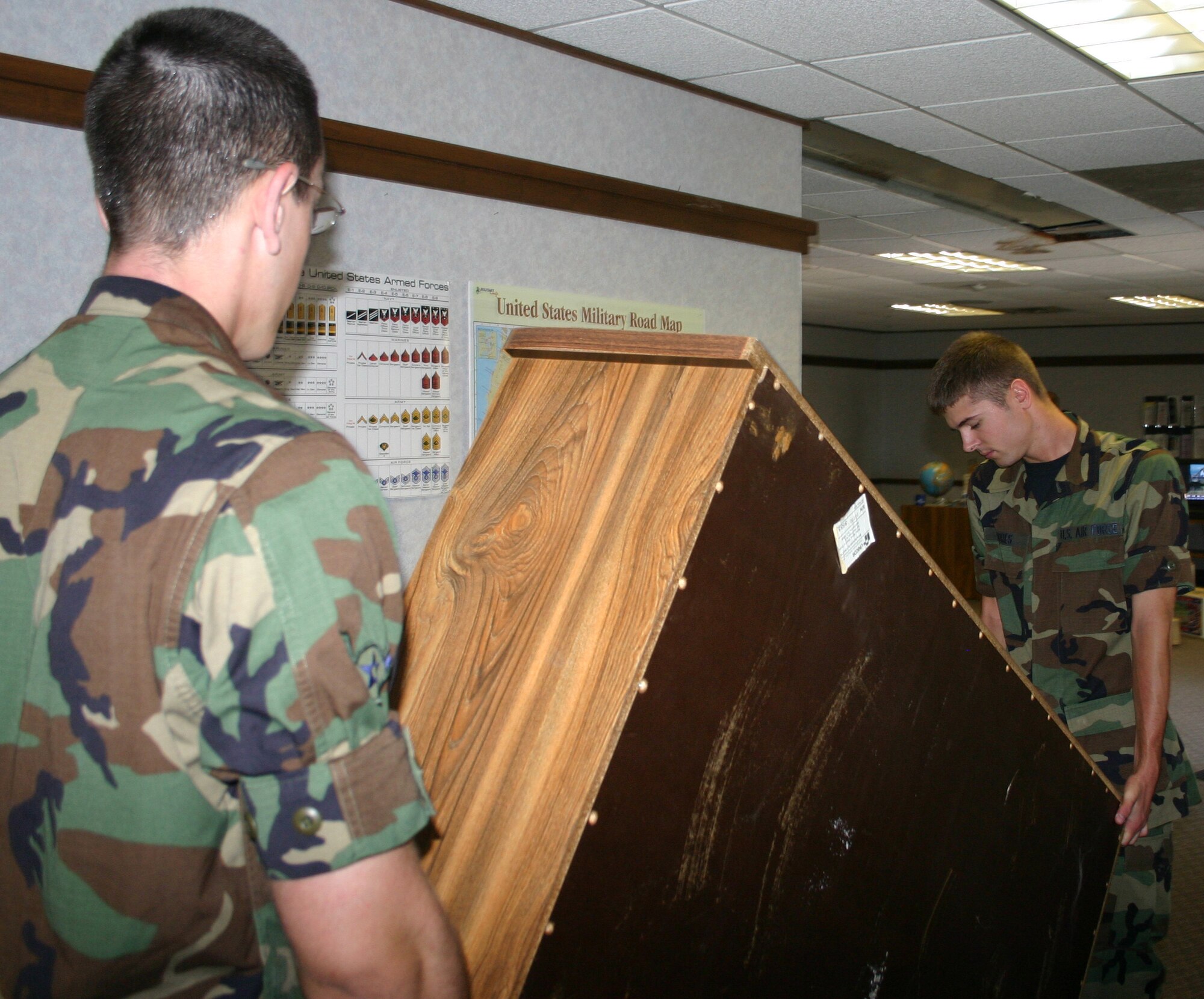 Airmen from the 362nd Training Squadron move a shelf from the old family support center to the new facility in Bldg. 962. (U.S. Air Force photo/Robert Fox)