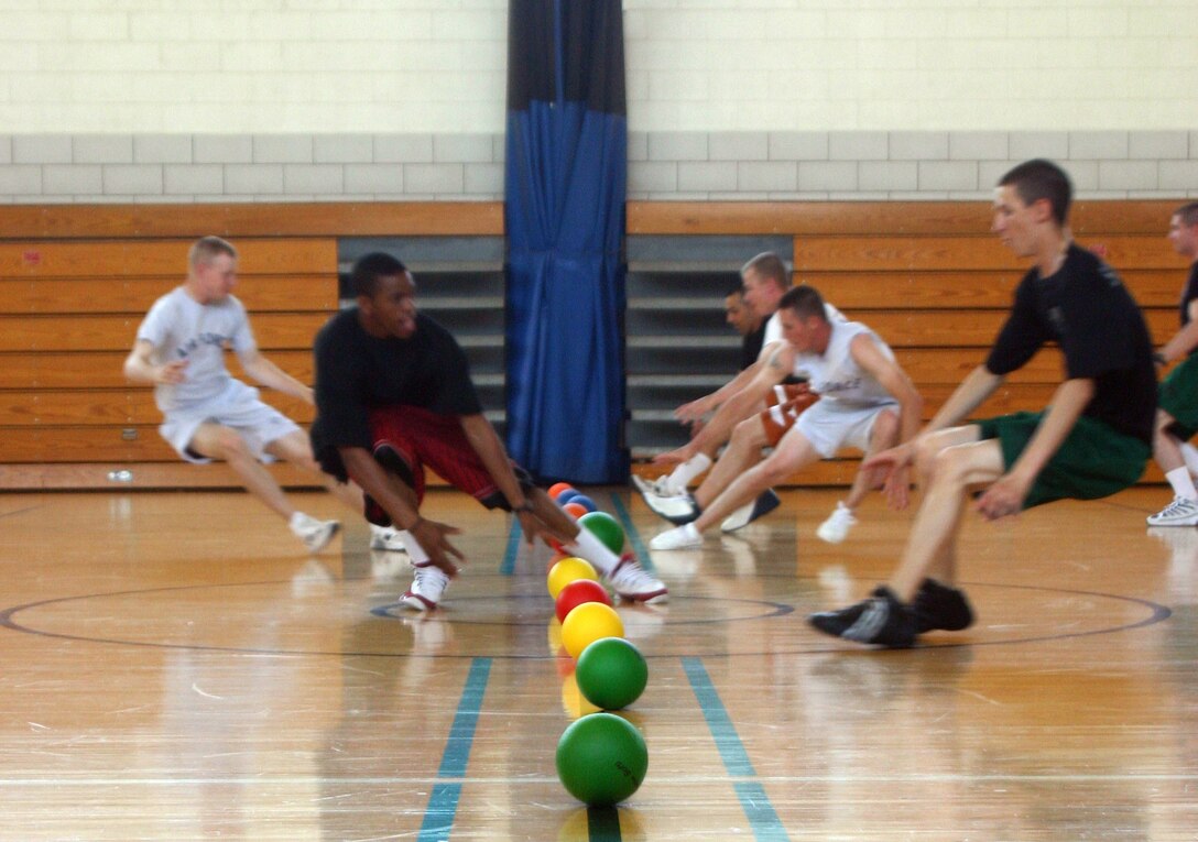 Participants in the FITS program dodgeball game race for balls in the center of the court while attemtping to avoid their opponents throws. (U.S. Air Force photo/Airman Jacob Corbin).