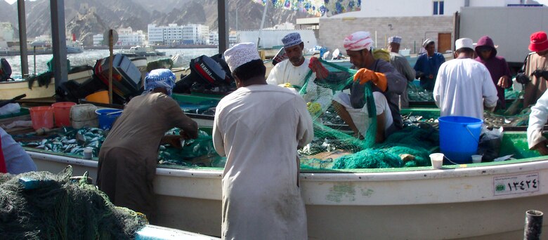 Omani fishermen sort through the day’s catch and untangle their nets. (U.S. Air Force photo).