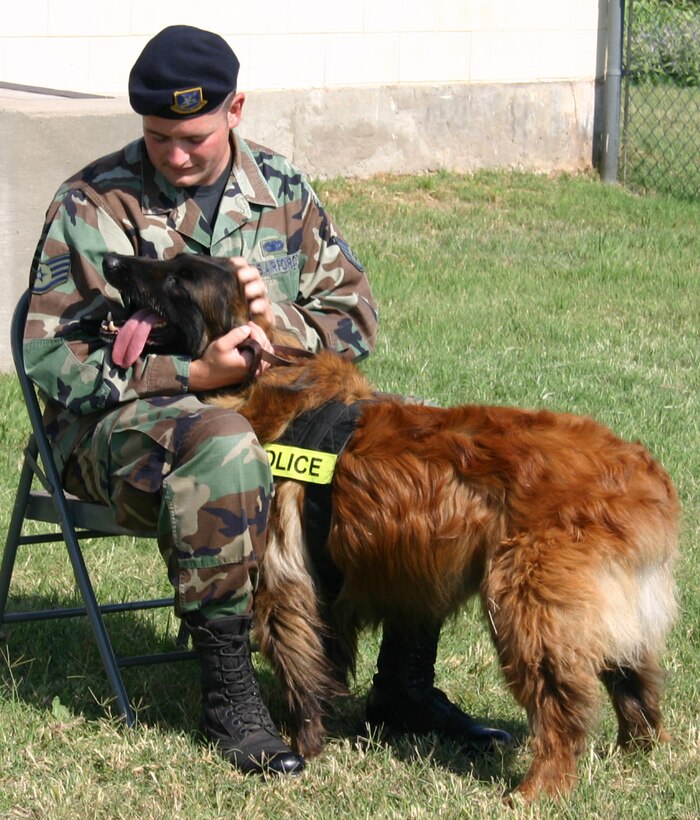 Staff Sgt. Thomas Butler, 82nd Security Forces Squadron, shows Charque, his military working dog, some affection during the dog’s retirement ceremony May 25. (U.S. Air Force photo/Staff Sgt. Jennifer Baxter).