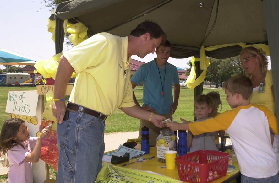 Kevin Curttright, 71st Operations Group honorary commander and owner of Curttright Honda in Enid, gives money to Trystan Helterbrand, son of Heather and Shane Helterbrand, Computer Sciences Corporation, and Jaxson Moore, son of Lori and Capt. Christopher Moore, 8th Flying Training Squadron, at the youth center’s Alex’s Lemonade Stand June 9. The youth center contributed more than $600 to the Alex’s Lemonade Stand Foundation for Childhood Cancer. The center has participated in the annual event for the past four years.(Photo by Staff Sgt. Amanda Savannah)