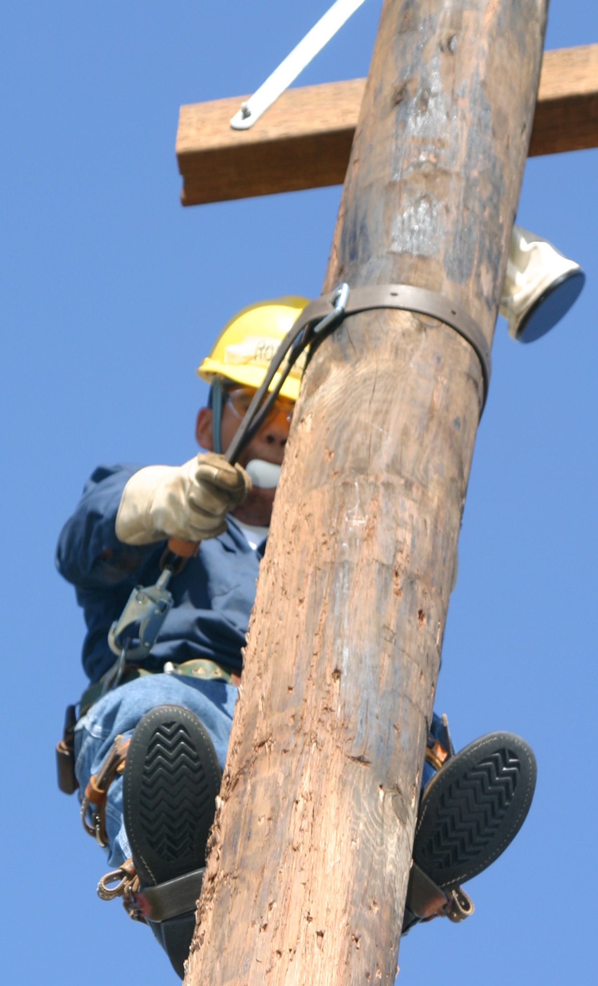 Pole jockeys competing in the Fourth Annual Lineman’s Rodeo May 20 had to complete the egg climb as quickly and safely as possible without breaking the egg they carried in their mouth. Above, Airman 1st Class Jose Rodriguez of the 366th Training Squadron prepares to go down a utility pole during the timed event. (U.S. Air Force photo/Senior Airman Tonnette Thompson).