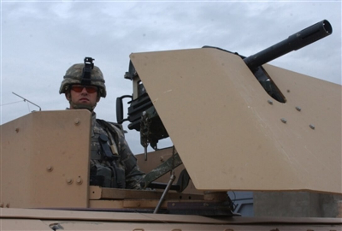 U.S. Army Spc. Kyle Kelly, from 1st Battalion, 12th Cavalry Regiment, 3rd Brigade Combat Team, 1st Cavalry Division from Fort Hood, Texas, provides security from the turret of a humvee in Kanan, Iraq, Nov. 7, 2006.
