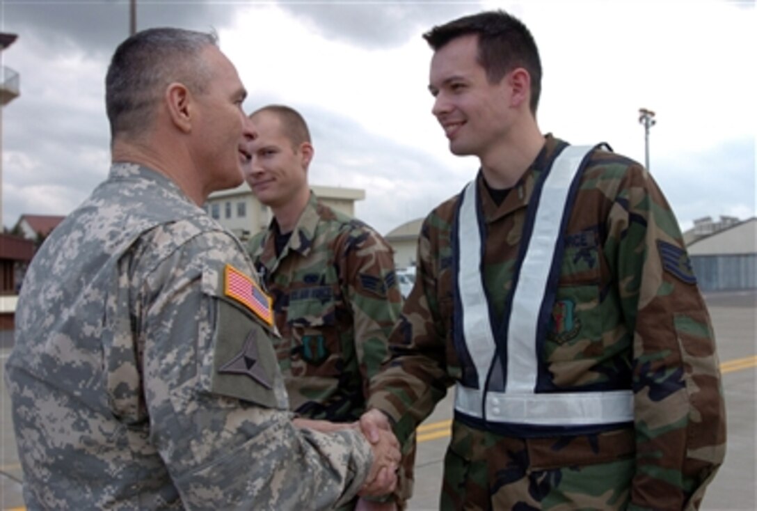 U.S. Army Command Sgt. Maj. William J. Gainey, the senior enlisted advisor to the Chairman of the Joint Chiefs of Staff, shakes hands with a U.S. Air Force airman as he arrives at Misawa Air Base, Japan, Nov. 8, 2006.