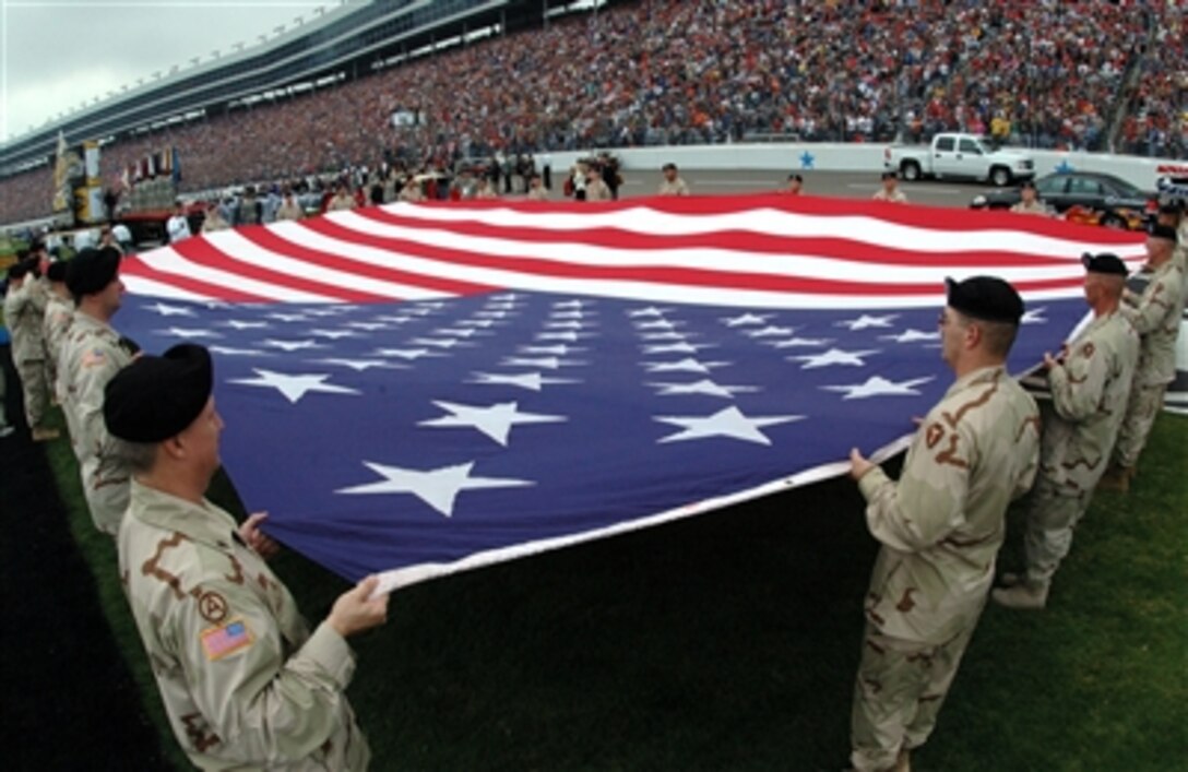 U.S. Army soldiers from the Grand Prairie Texas' 2nd Battalion, 149th Aviation Regiment, hold the nation's Colors for the National Anthem prior to the start of the NASCAR Dickies 500 race at the Texas Motor Speedway, Nov. 5, 2006.