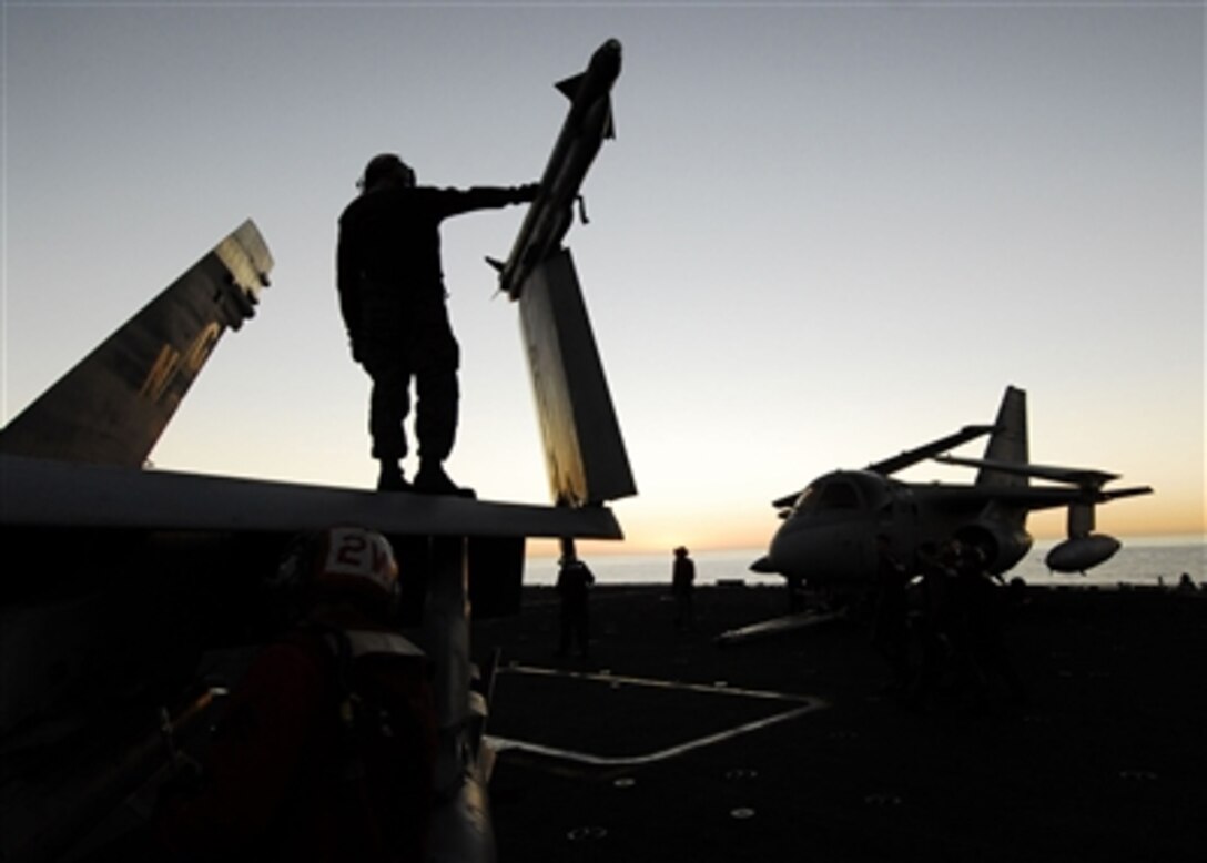 U.S. Navy flight deck crewmembers finish aircraft maintenance checks after a long day of flight operations on the aircraft carrier USS John C. Stennis (CVN 74) on Nov. 7, 2006.  Stennis is serving as the flagship for Commander, Carrier Strike Group 3 in a joint task force exercise.  