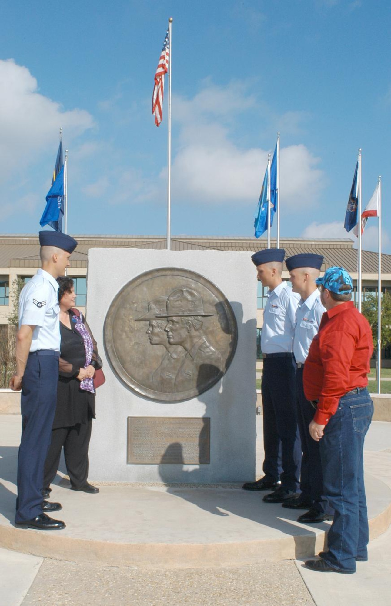 The Hatcher brothers and their parents Linda Gelski, left, and Danny Hatcher, view the Military Training Instructor Memorial behind the 37th Training Wing Headquarters at Lackland.  The basic training graduates are, left to right, Airman First Class Logan and Airmen Basic Chaz and Derek. (U.S. Air Force photos/Alan Boedeker)