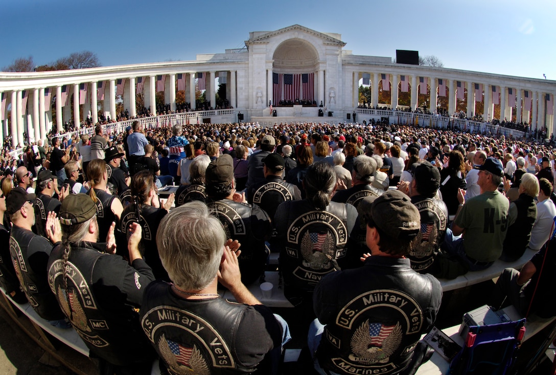 Members of the Northern Virginia Chapter of U.S. Military Vets Motorcycle Club and thousands of other visitors to Arlington National Cemetery applaud as President George W. Bush takes the stage at the Tomb of the Unknown Soldier for the Veterans Day ceremony at Arlington National Cemetery, Nov. 11, 2006.