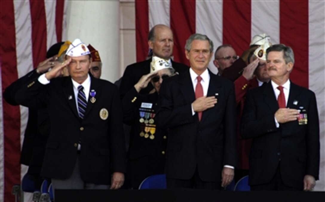 Left to right, Tom Poulter, national commander of the Military Order of the Purple Heart of the U.S.A., George W. Bush, U.S. president, and James Nicholson, chairman of the Veterans Day National Committee, participate in the pledge of allegiance during the Veterans Day ceremony at Arlington National Cemetery, Nov. 11, 2006.  