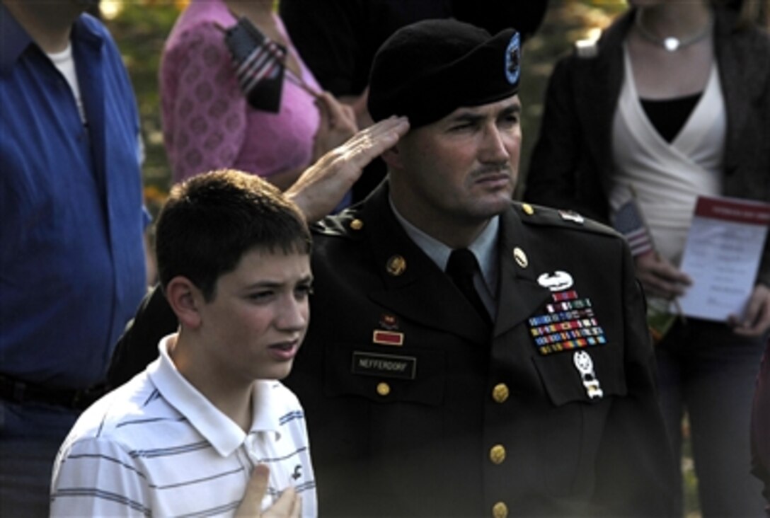 U.S. Army Master Sgt. Dan Nefferdorf and his son Daniel Nefferdorf, Jr., render honors during the singing of the National Anthem as part of a Veterans Day ceremony at the Vietnam War Memorial, Nov. 11, 2006.  