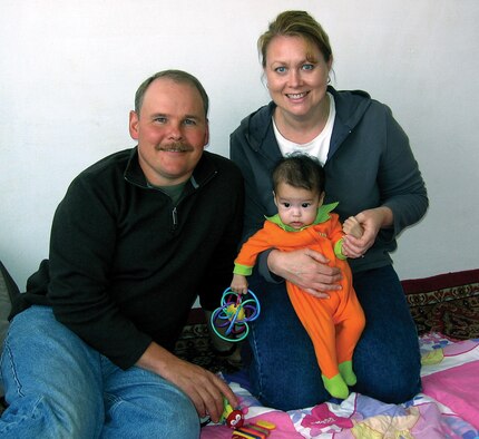 MCCHORD AIR FORCE BASE, Wash., - Senior Master Sgt. Lance Gustafson sits beside his wife, Denice, who holds 8-month-old Ana at the orphanage in Kazakhstan.  Sergeant Gustafson is a Air Force Reserve loadmaster at the 446th Operations Group here. (Courtesy photo provided by Senior Master Sgt. Lance Gustafson)