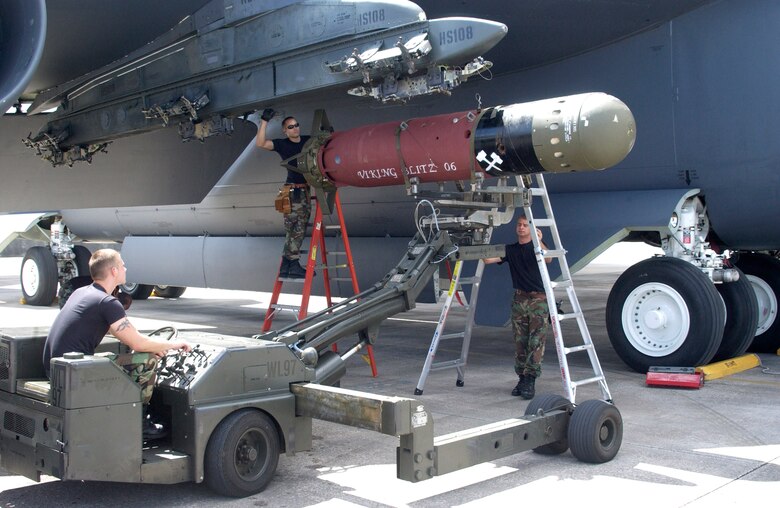 Staff Sgt. Joshua Sweet (right) guides Airman 1st Class Wayne Robinson as he positions an Mk 56 mine under the wing of a B-52 Stratofortress.  Staff Sgt. Jason Smith (on ladder) and Sergeant Sweet will secure the weapon once it is in position. The three are weapons loaders with the 36th Expeditionary Aircraft Maintenance Squadron at Andersen Air Force Base, Guam.  (U.S. Air Force photo/Staff Sgt. Eric Petosky) 