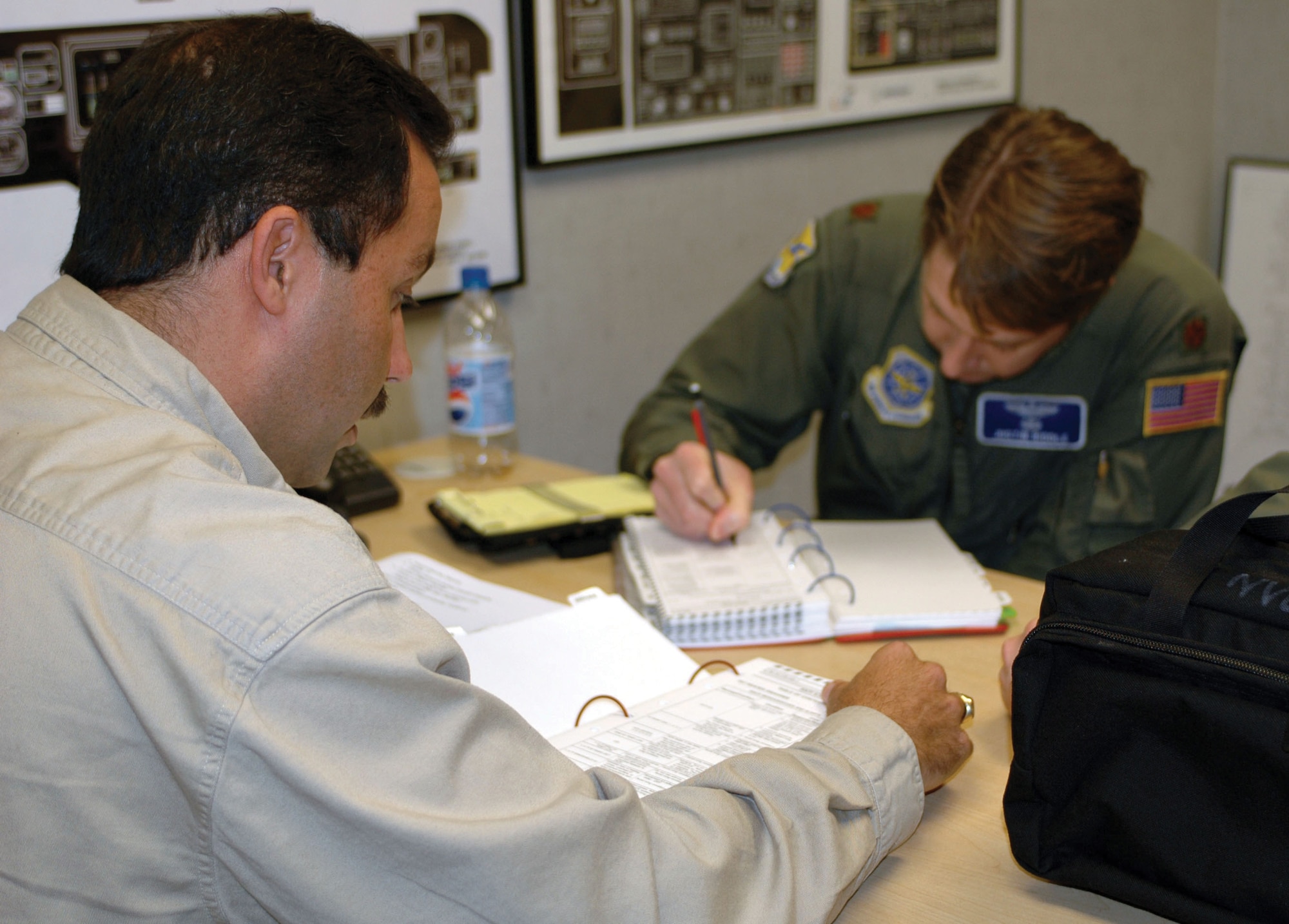 Pedro Ramos, a contracted  instructor for the C-17 simulator at McGuire Air Force Base, N.J., briefs Maj. Justin Riddle, 436th Airlift Wing pilot, on the operations they will be conducting during simulator training Nov. 2. Mr. Ramos is also a reserve pilot and major with the 512th Airlift Wing's 326th Airlift Squadron. The simulator session was part of an interfly agreement Nov. 1-5 with the 305th Air Mobility Wing, McGuire Air Force Base, N.J., to assist Dover Air Force Base with its training and transition to the C-17. (U.S. Air Force photo by 1st Lt. Marnee A.C. Losurdo)
