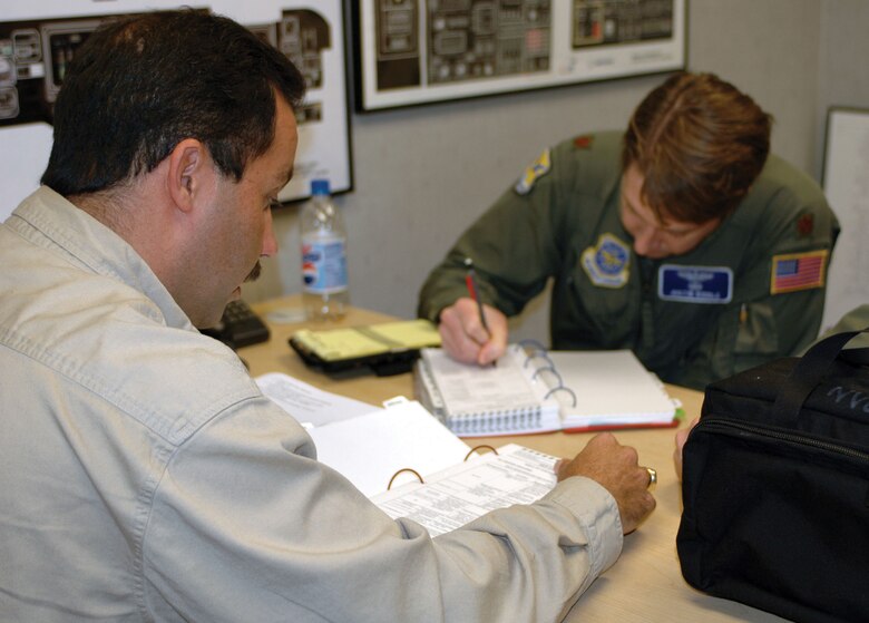 Pedro Ramos, a contracted  instructor for the C-17 simulator at McGuire Air Force Base, N.J., briefs Maj. Justin Riddle, 436th Airlift Wing pilot, on the operations they will be conducting during simulator training Nov. 2. Mr. Ramos is also a reserve pilot and major with the 512th Airlift Wing's 326th Airlift Squadron. The simulator session was part of an interfly agreement Nov. 1-5 with the 305th Air Mobility Wing, McGuire Air Force Base, N.J., to assist Dover Air Force Base with its training and transition to the C-17. (U.S. Air Force photo by 1st Lt. Marnee A.C. Losurdo)
