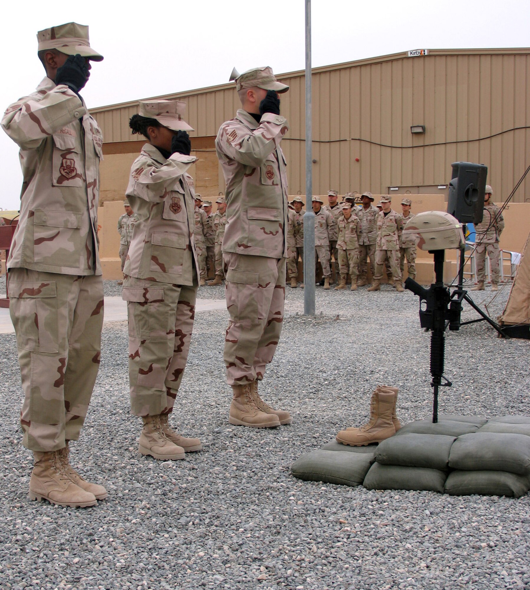 Members of the 386th Expeditionary Security Forces Squadron salute the display they set up during a remembrance ceremony for Airman 1st Class Elizabeth Jacobson, who was killed while on a convoy near Camp Bucca, Iraq, when her vehicle was hit by an improvised explosive device Sept. 28, 2005. She was the first female Airman killed in the line of duty supporting Operation Iraqi Freedom. (U.S. Air Force photo/Staff Sgt. Ian Carrier)
