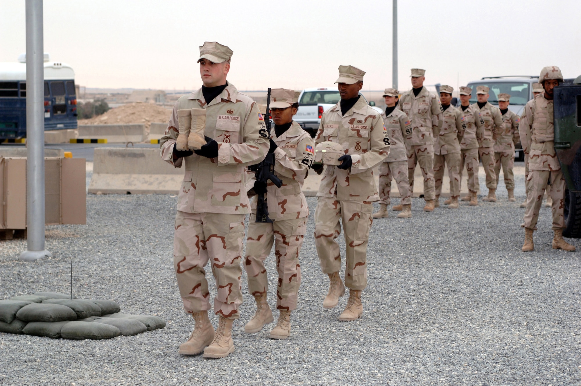 Members of the 386th Expeditionary Security Forces Squadron march toward a memorial site for Airman 1st Class Elizabeth Jacobson, who was killed while on a convoy near Camp Bucca, Iraq.  Her vehicle was hit by an improvised explosive device Sept. 28, 2005. She was the first female Airman killed in the line of duty supporting Operation Iraqi Freedom. Senior Airman Nykita Stoudemire, deployed with Airman Jacobson last year, placed the M-4 assault rifle during the ceremony. (U.S. Air Force photo/Tech. Sgt. Andy Bellam)
