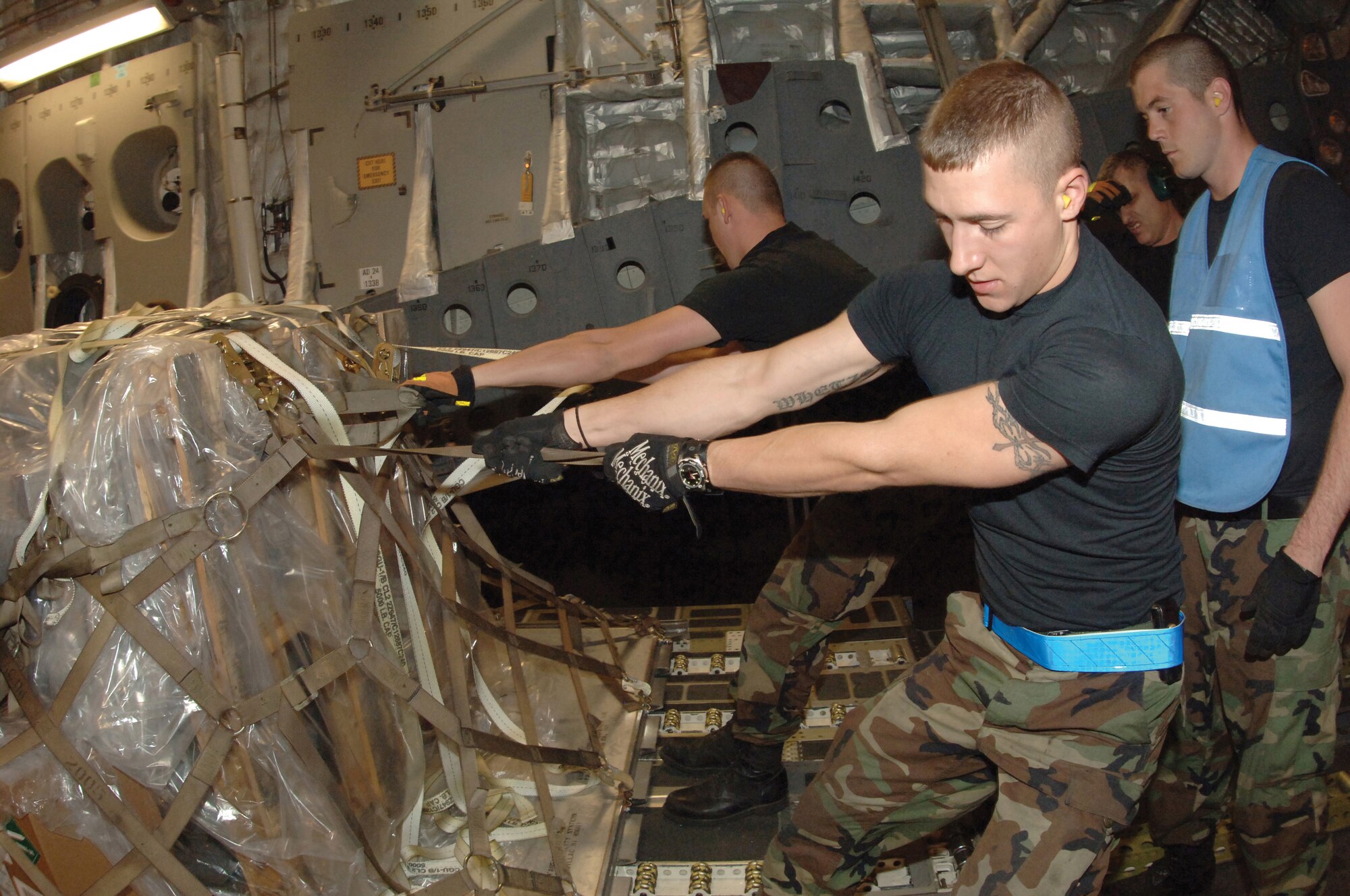 Senior Airman John W. Smith, right, 728th Air Mobility Squadron aerial porter, loads palletes onto a C-17 Globemaster III with the aid of Tech. Sgt. Tom House, 728th AMS aircraft loadmaster. Risk management can range from wearing protective gloves and reflective belts to assessing the risk of moving the exact amount of cargo on any mission. Risk management should be executed during every activity. (U.S. Air Force photo by Master Sgt. Bill Gomez.)