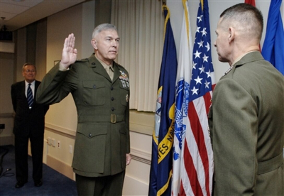 Defense Secretary Donald H. Rumsfeld (left) looks on as Chairman of the Joint Chiefs of Staff Marine Gen. Peter Pace (right), administers the oath to U.S. Marine Corps Gen. James T. Conway (center), during his promotion ceremony, Nov. 13, 2006.  