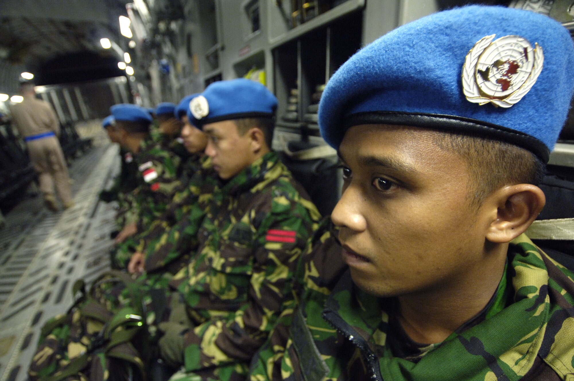 Indonesian peacekeeping troops reflect on the mission ahead as the C-17 Globemaster III loadmaster makes one last check of the area before takeoff Nov. 8.  They are deploying to Lebanon in support of UNIFIL, the United Nation's Interim Force in Lebanon.  (U.S. Air Force photo/Tech. Sgt. John M. Foster)