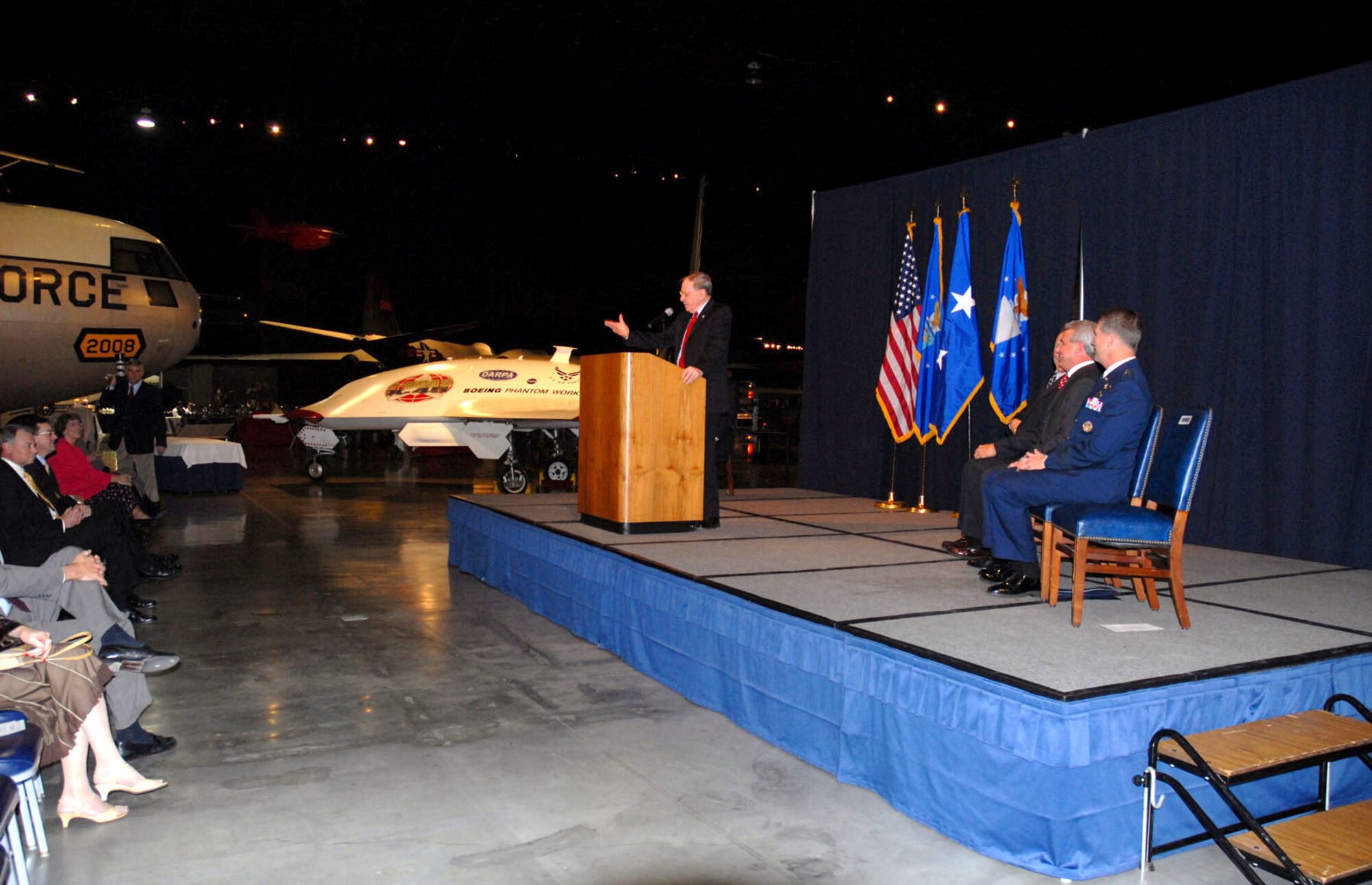 The Boeing X-45A unmanned combat air vehicle was officially inducted into the National Museum of the United States Air Force collection during a special ceremony on Nov. 13, 2006. Here, retired Maj. Gen. Charles D. Metcalf, museum director, addresses the audience. (U.S. Air Force photo)