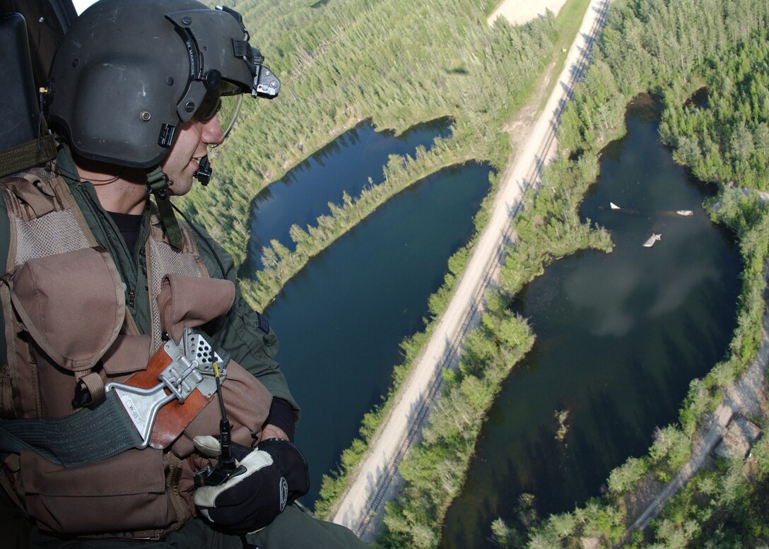 EIELSON AIR FORCE BASE, Alaska - Staff Sgt Dave Torrance of the 210th Rescue Squadron from Elmendorf AFB, Alaska looks down at the Lady of the Lake as they return from their exercise here on June 20, 2006. Lady of the Lake is the final resting place for a WB-29 Aircraft that crashed and was later towed to that lake for underwater extrication training. (U.S. Air Force Photo by Airman Jonathan Snyder)