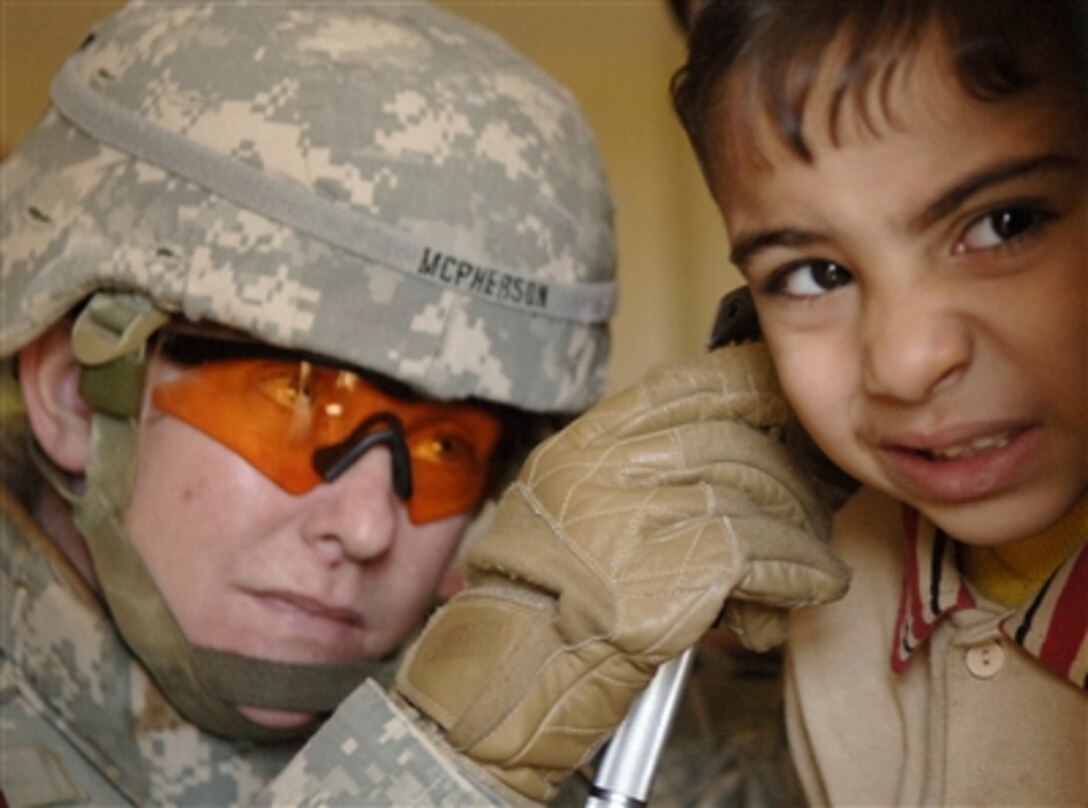 U.S. Army Capt. Cindy McPherson examines an Iraqi boy's ears during a medical and humanitarian mission in Baghdad, Iraq, on Nov. 9, 2006.  McPherson is a physicianís assistant with the 172nd Stryker Brigade Combat Team.  
