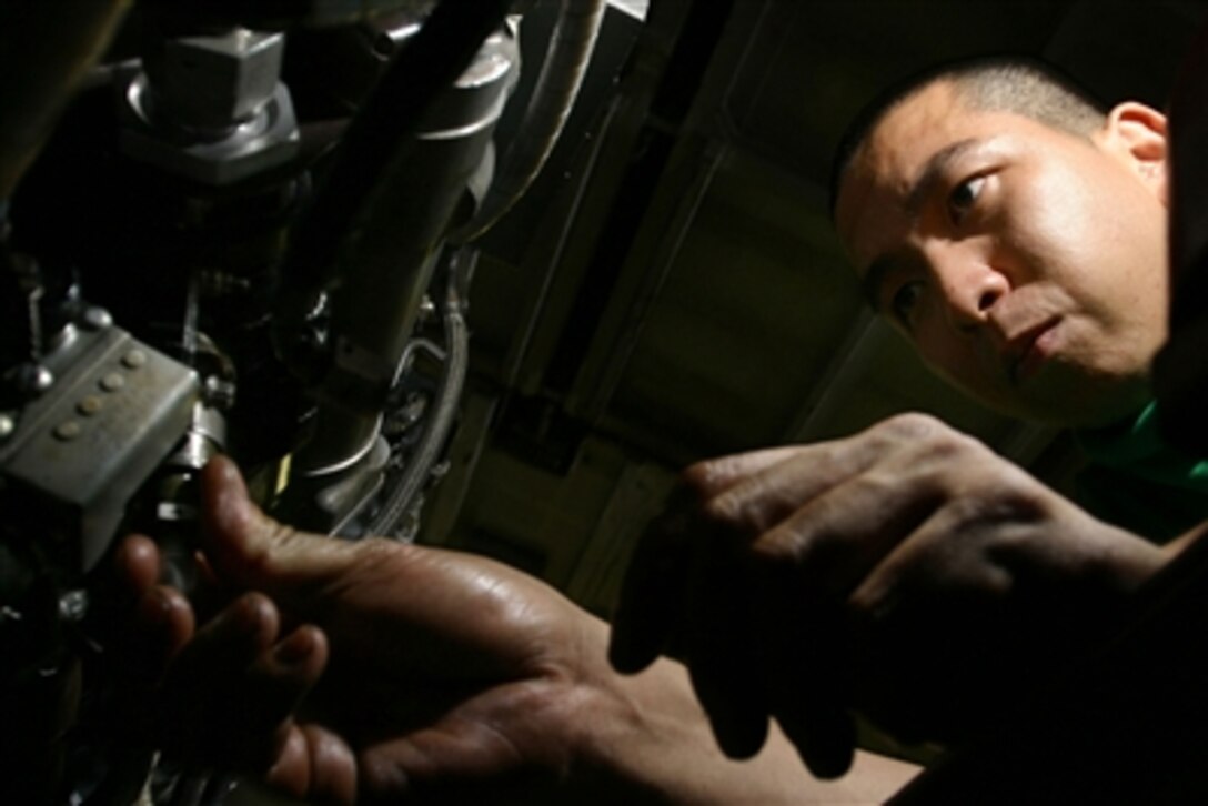 Petty Officer 2nd Class Christian Tan prepares a J52 jet engine for installation into an EA-6B Prowler aircraft in the hangar deck of the aircraft carrier USS Kitty Hawk (CV 63) as the ship operates in the waters off southern Japan on Nov. 3, 2006.  Tan is a U.S. Navy aviation machinist's mate onboard the carrier.  