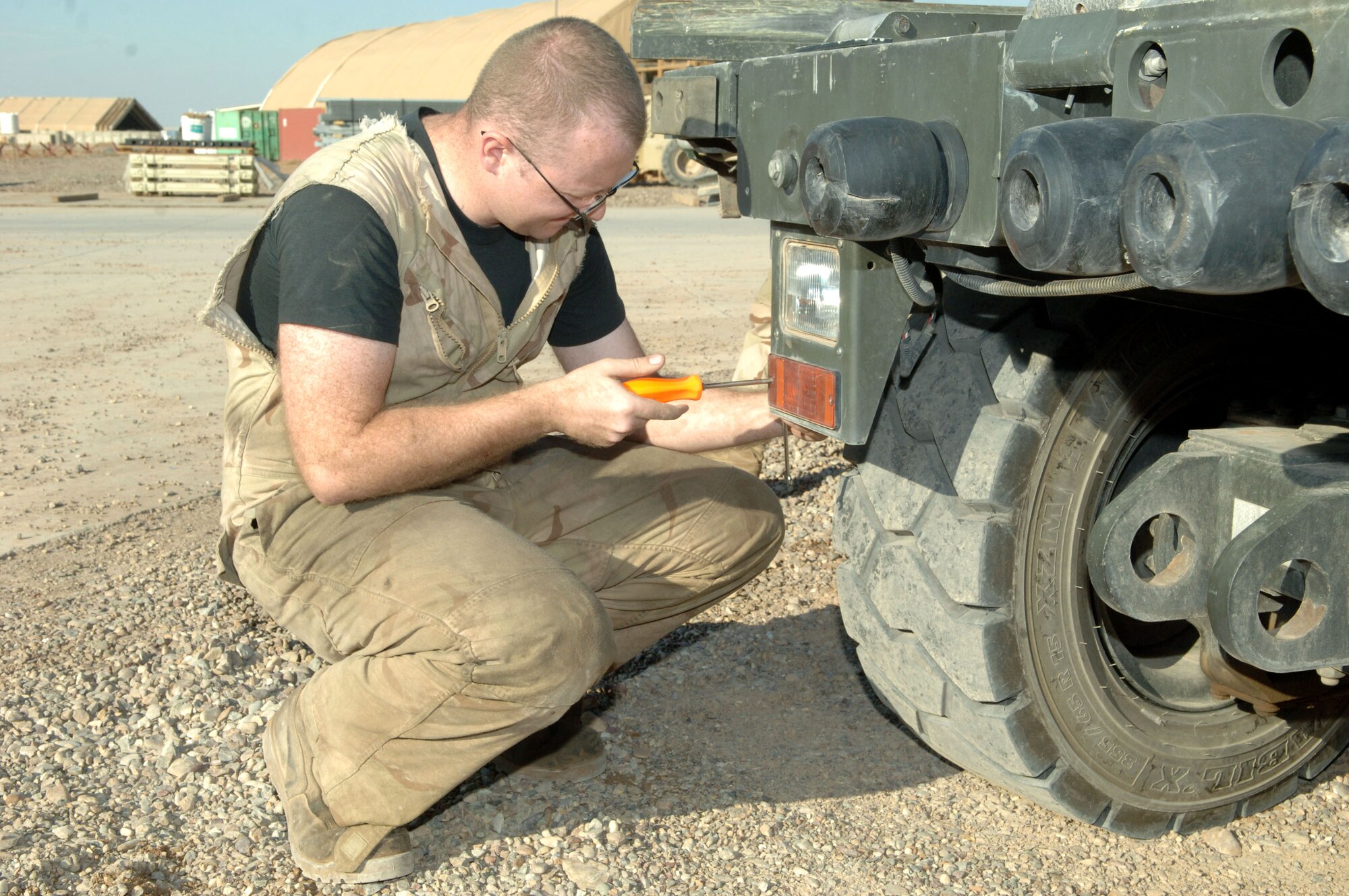 Senior Airman Devin Sigle, 332nd Expeditionary Logistics Readiness Squadron, replaces a parking light bulb at Balad Air Base, Iraq. Airman Sigle is a vehicle maintenance journeyman deployed from Yokota Air Base, Japan. (U.S. Air Force photo/Airman 1st Class Chad Kellum)