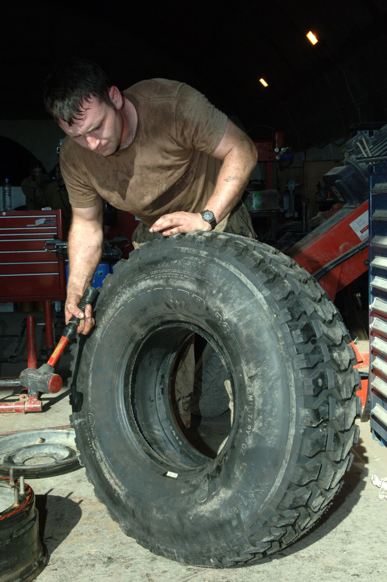 Senior Airman Richard Lober, 332nd Expeditionary Logistics Readiness Squadron, checks for wear and tear on a tire  in the maintenance shop at Balad Air Base, Iraq. Airman Lober is a vehicle maintenance journeyman deployed from Royal Air Force Lakenheath, England.  (U.S. Air Force photo/Airman 1st Class Chad Kellum)
