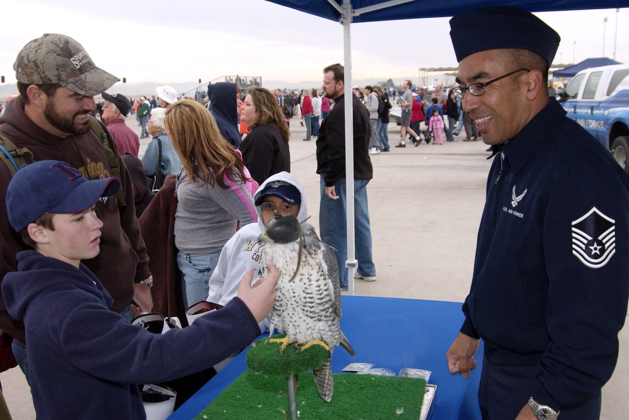 Master Sgt. Gino Mattorano of the U.S. Air Force Academy shows a young air show spectator a Falcon mascot named "Cody" Nov. 11 at Nellis Air Force Base, Nev. Aviation Nation 2006 is one of the largest aviation events in North America. The show was held Nov. 11 and 12. (U.S. Air Force photo/Master Sgt. Kevin J. Gruenwald)