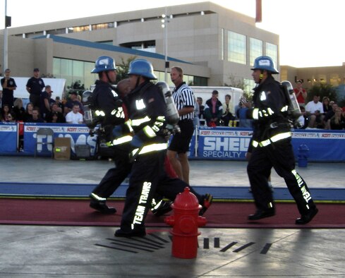 Members of the Team Travis Firefighter Combat Challenge Team race against the clock during the "dummy drag" portion of the competition. During the competition, firefighters from around the world had to perform five different tasks, including a simulated rescue of a life-sized, 175-pound "victim." Team Travis won the competition for the third consecutive year. (U.S. Air Force photo/Senior Master Sgt. Jeff Vaughn)
