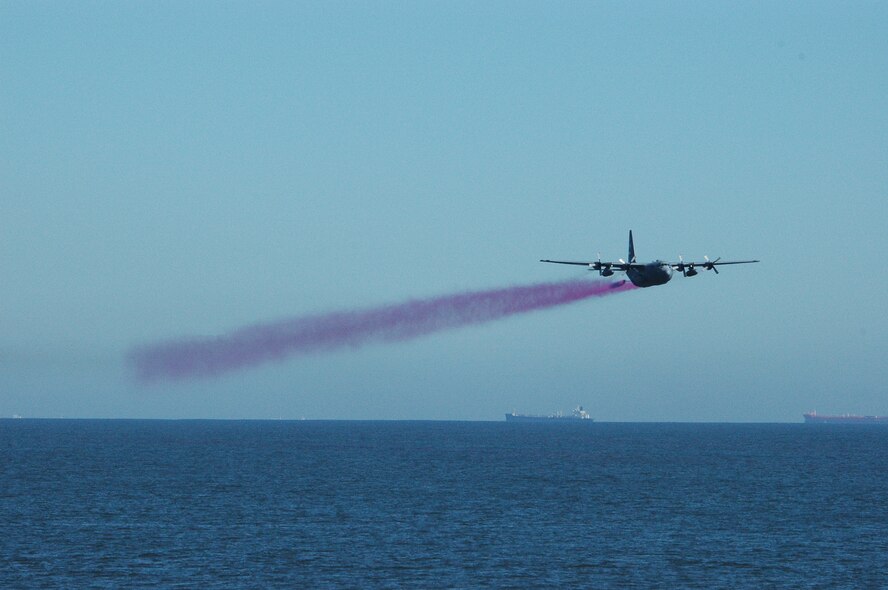 THE GULF OF MEXICO – Brightly colored water sprays from the booms of an aerial spray modified C-130H during a oil dispersant exercise six miles off the shores of Galveston, Texas, Nov. 8, 2006.  The exercise, which was developed by the Texas General Land Office, included both military and civilian aerial spray aircraft.  