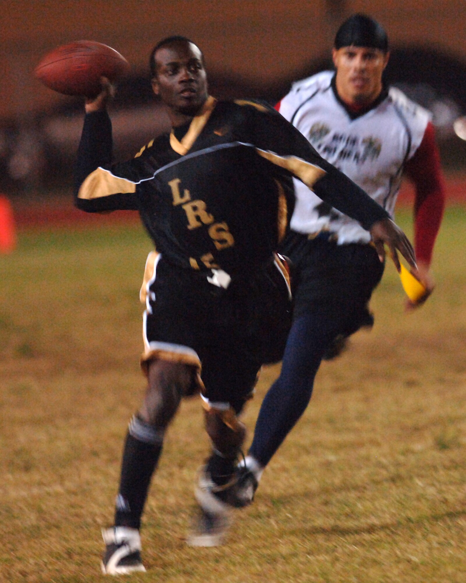 Byran Shipman, 39th Logistice Readiness Squadron quarterback, looks for an open reciever with Edwin Lopez, 39th Contracting Squadron/Civil Engineer Squadron defensive end, in hot pursuit during the Incirlik Intramural Championship game Nov. 14. LRS defeated CONS/CES 18-12 in overtime. (U.S. Air Force photo by Airman 1st Class Nathan W. Lipscomb)