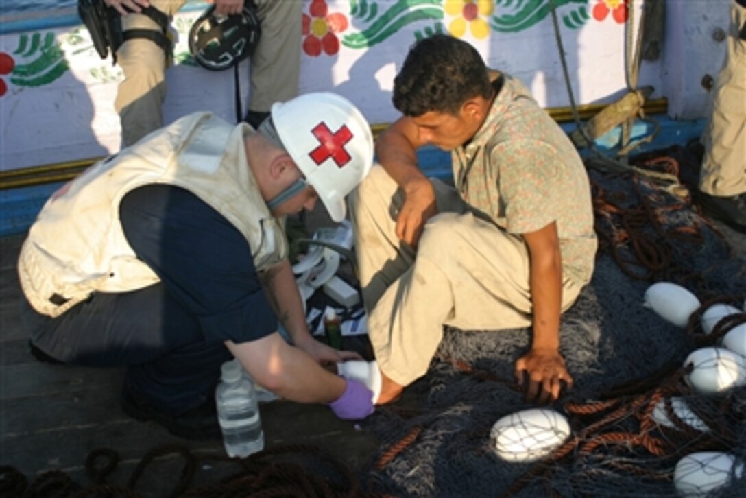 U.S. Navy Petty Officer 3rd Class Brandin Huggett, from the rescue and assistance team aboard the guided-missile cruiser USS Anzio, treats a crewmember aboard the Al Shams, a Pakistani dhow, in the Arabian Sea, Nov. 13, 2006. Anzio supplied the dhow's crew with water, food and medical attention.