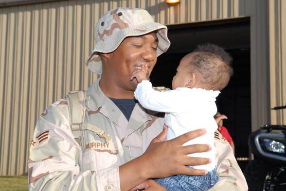 Senior Airman Calvin Murphy, an engineering assistant with the 97th Civil Engineer Squadron, greeted his 7-month-old daughter, Anisa, for the first time Nov. 9.  Airman Murphy was one of 27 CES troops to return from a  deployment that day.  The troops trickled in from morning to late evening following deployments to Balad Air Base, Iraq.   (U.S. Air Force photo by Senior Airman Mercedes Crossland)